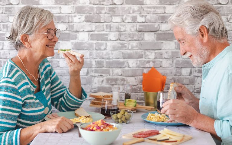Senior couple enjoying tooth-friendly foods and drinks at a table