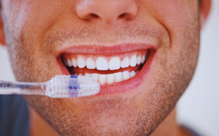 Close-up of man brushing teeth, promoting strong teeth and healthy gums