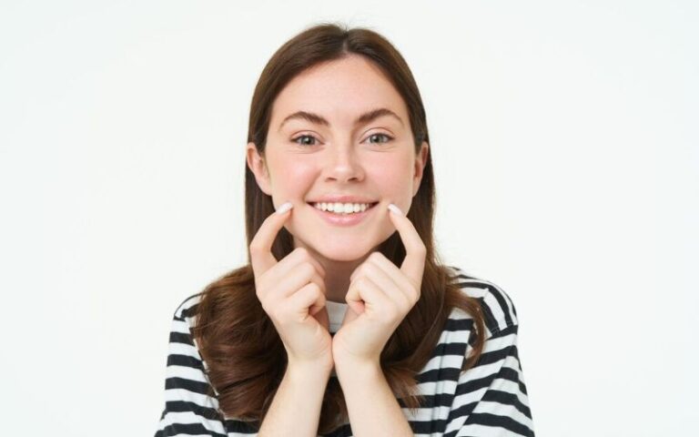 Woman smiling confidently after cosmetic dentistry treatment for overbite