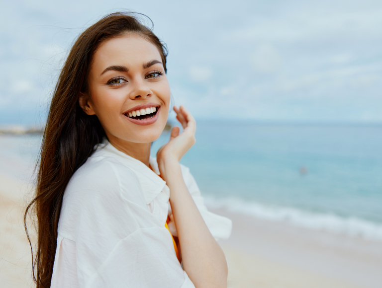 Smiling woman showing straight teeth after 6-Month Smiles orthodontic treatment