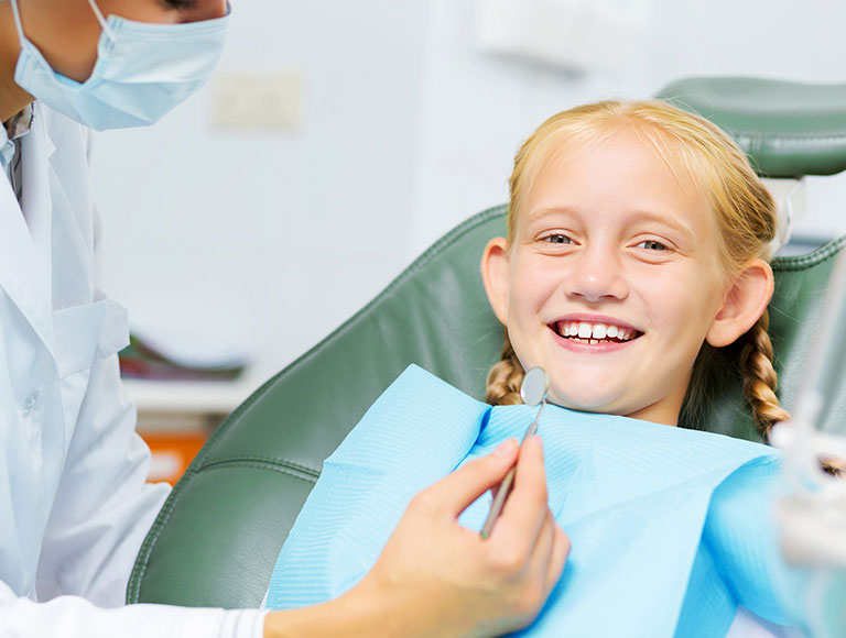 Child smiling during dental sealants appointment