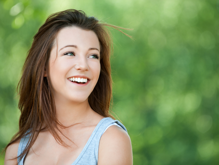 Happy female patient recovering from tooth extraction in Huntington Beach