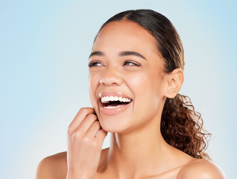 Smiling woman showing cosmetic dental results in Huntington Beach