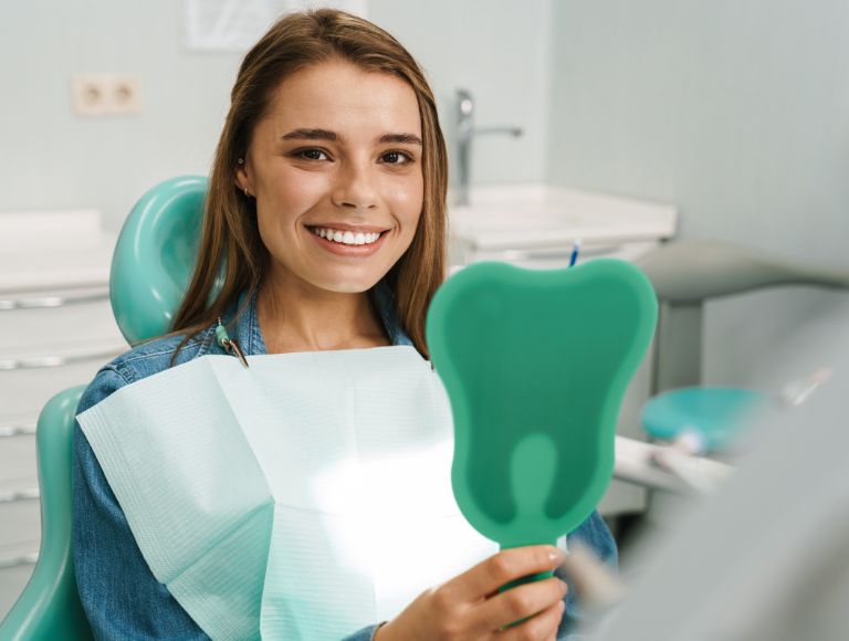 woman smiling post dental crowns procedure in huntington beach