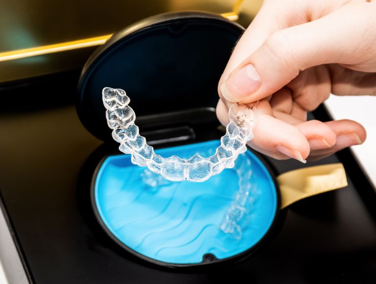 Clear aligner shown before placement, representing orthodontic care at Cleopatra Dental Huntington Beach.