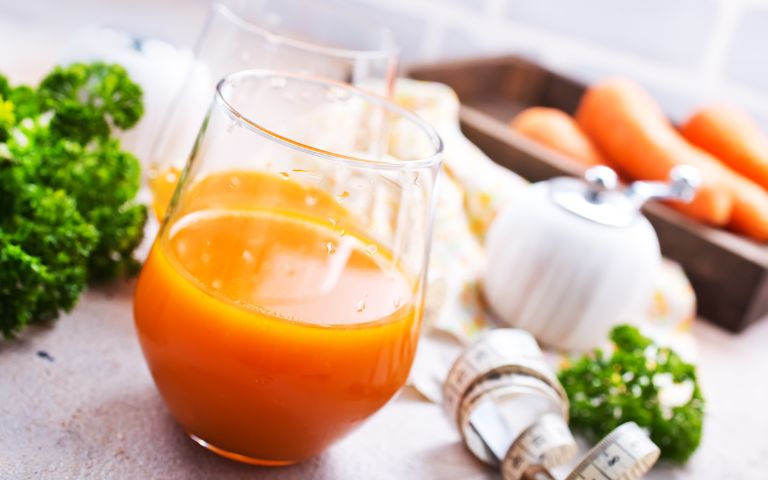 Glass of carrot juice with fresh vegetables – summer tip for healthy teeth